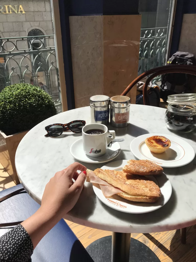 Simple café breakfast with coffee, pastry, and sandwich in natural light, representing slow living and an analog lifestyle in 2026