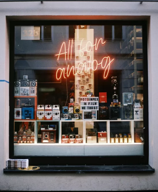 Analog camera shop window with film cameras and neon sign reading “All for analog,” representing a low-tech lifestyle and intentional living in 2026